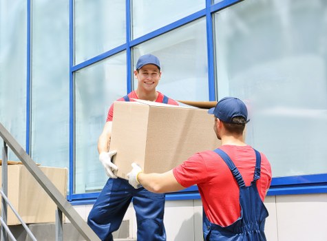 Professional movers carrying furniture through an East London property