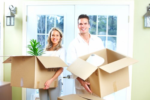 Professional movers carrying furniture through a Homerton property